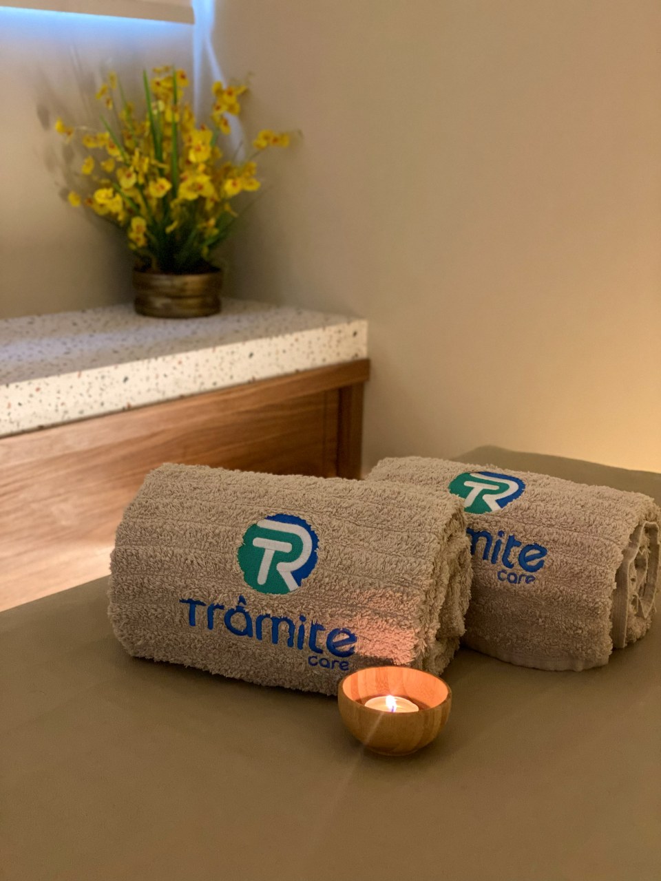 Toalhas Trâmite Care e vela aromática preparadas na sala de massagem